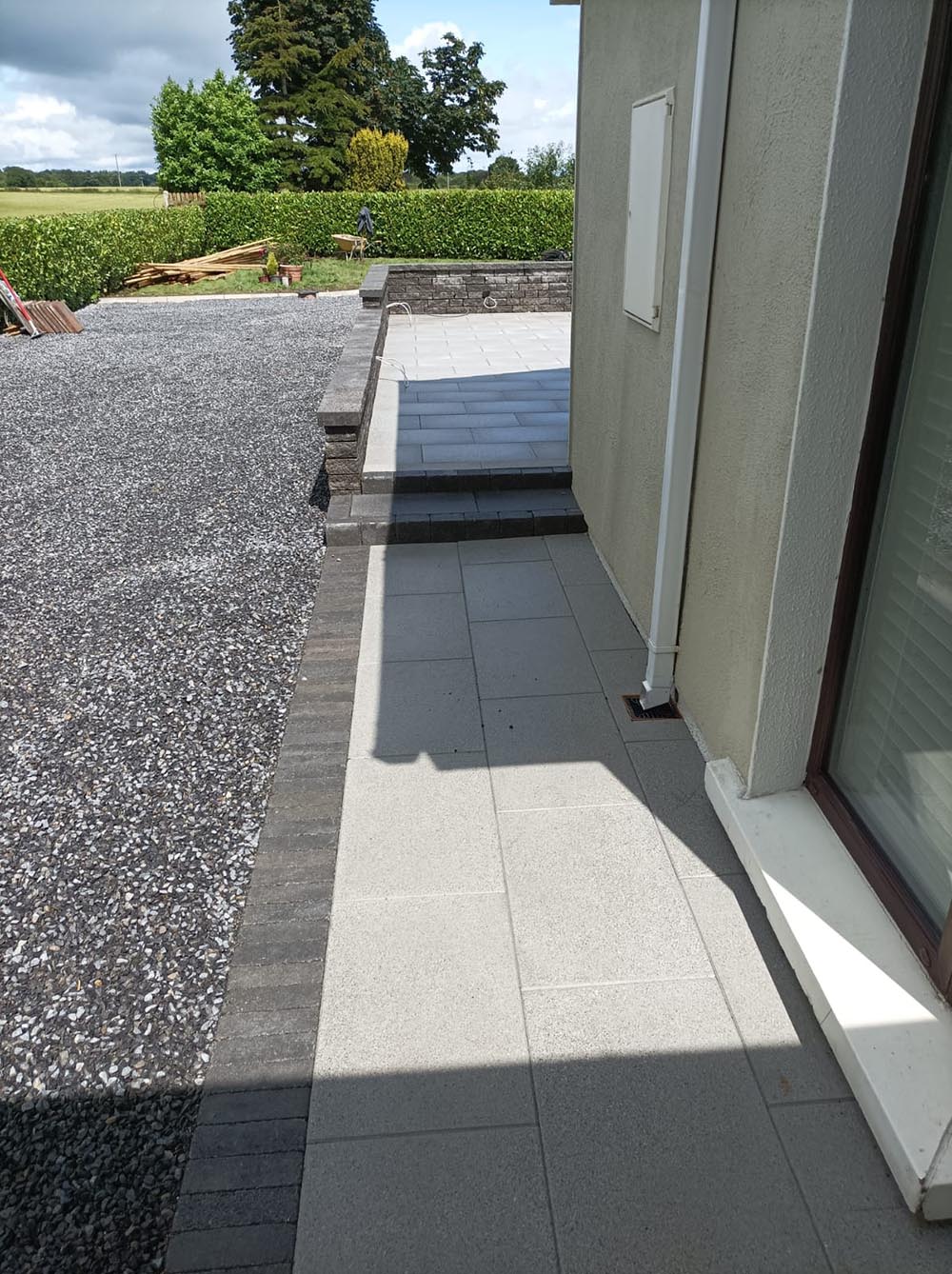 Paved walkway down the side of a house